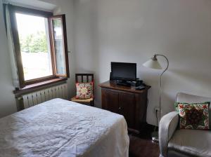 a bedroom with a bed and a tv and a chair at Appartamento Belvedere Abetone in Abetone
