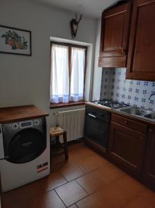 a kitchen with a dishwasher and a sink and a stove at Appartamento Belvedere Abetone in Abetone +17 photos