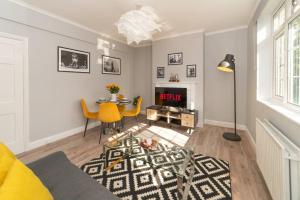 a living room with a table and a dining room at Stylish 2 Bedroom Apartment with Balcony in Balham in London