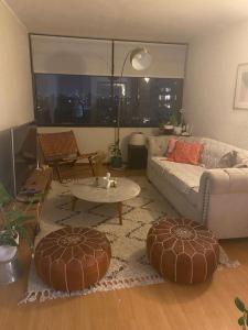 ein Wohnzimmer mit Sofa und Tisch in der Unterkunft Providencia, ubicación y vista extraordinaria, con AC in Santiago
