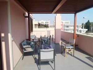 un patio con sedie e tavoli su un balcone di La Terrazza Salentina attico indipendente con parcheggio a Lecce