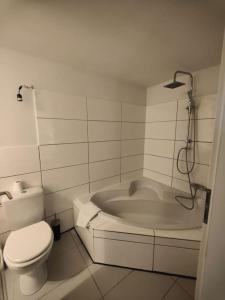 ein Badezimmer mit einem WC und einer Badewanne in der Unterkunft Historische Wohnung am Jenischpark in Hamburg