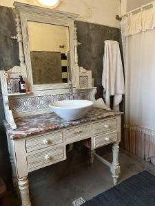 a bathroom with a sink and a large mirror at Estancia Laserca 