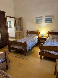 a bedroom with two beds and a table with a lamp at Estancia Laserca 