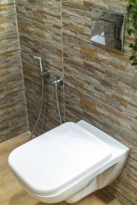 - białą toaletę w łazience z ceglaną ścianą w obiekcie Bardis Hidden Gem w mieście Wolos