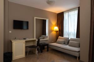a hotel room with a couch and a table and a desk at St. George Hotel in Sofia