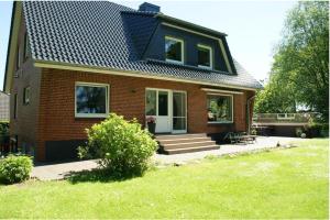 a small brick house with a black roof at Ferienwohnung-Auszeit in Hürup