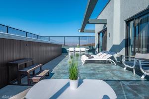 - un balcon avec des bancs et des tables dans un bâtiment dans l'établissement סוויטות בוטיק נעמי, à Netu'a