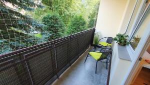 a balcony with two chairs and a large window at Comfort Apartament in Rzeszów