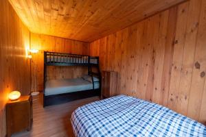 a bedroom with a bed in a wooden room at Chalet in a dark sky reserve in Notre-Dame-Des-Bois