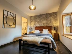 een slaapkamer met een bed en een spiegel aan de muur bij Le clos des pierres rouges in Saint-Privat-dʼAllier