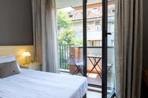 a hotel room with a bed and a balcony at St. George Hotel in Sofia