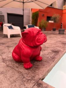 una estatua de perro rojo sentada en una cornisa en Lbkn, en Toulouse