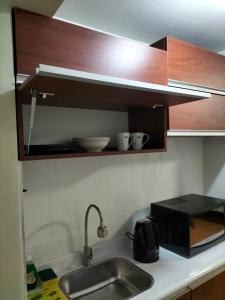 encimera de cocina con fregadero y microondas en Lugar cómodo y seguro, en Lima