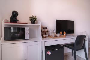einen weißen Schreibtisch mit einer Mikrowelle und einem Computer in der Unterkunft B&B Vatican Stories in Rom