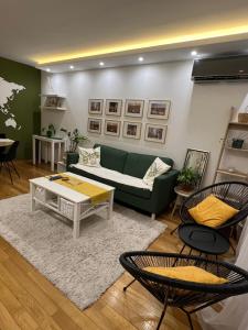- un salon avec un canapé vert et des chaises dans l'établissement Happy green home, à Fontana