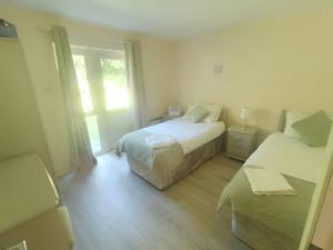 a bedroom with two beds and a window at Kilarney cottage in Killarney