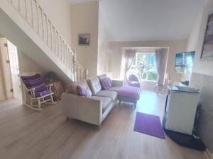 a living room with a couch and a staircase at Kilarney cottage in Killarney