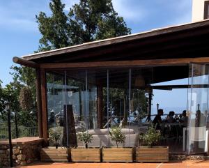 un ristorante con pareti in vetro e persone sedute ai tavoli di Casale Calabria a Gizzeria