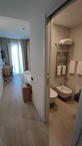bagno con lavandino, servizi igienici e specchio di Splendid Hotel Taormina a Taormina