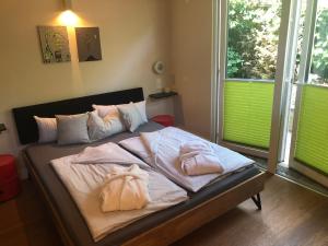 Schlafzimmer mit einem Bett mit weißer Bettwäsche und Kissen in der Unterkunft relactive-mosel Feriendomizil in Traben-Trarbach