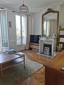 a living room with a fireplace and a mirror at Home sweet home in Paris