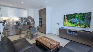 un salon avec un canapé, une télévision et une table dans l'établissement Apt 2 Chambres - Direct Gare Part-Dieu, Lyon - Ascenseur & Wi-Fi Gratuit, à Lyon