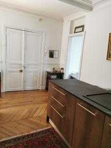a kitchen with a black counter top and wooden floors at Home sweet home in Paris +4 photos
