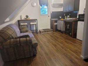 a living room with a couch and a kitchen at Cute apartment close to highway in Edmundston