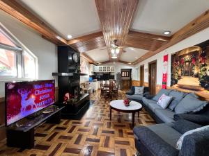 a living room with a couch and a tv at CAMPJOHNHAY Forest Estate in Baguio