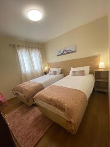 two beds in a hotel room with at Casa do Cantinho do Muro in São Vicente