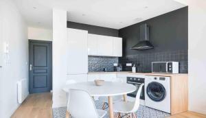 a kitchen with a white table and a washing machine at Appartement neuf • Cosy et Lumineux • 4 personnes in Marseille