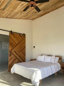 1 dormitorio con 1 cama y puerta de madera en Beautiful Private Villa, Views in Every Direction, en Bolívar