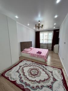 een slaapkamer met een roze bed en een groot tapijt bij 1 комнатная квартира Аппартаменты ЖК Aspan city in Alma-Ata