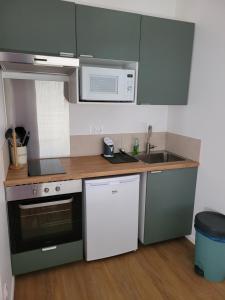 Appartement cosy في Saint-Martin-Longueau: مطبخ صغير مع حوض وميكروويف