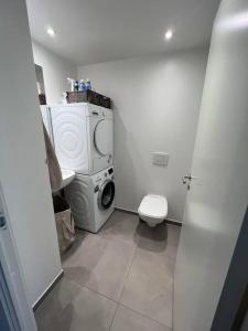 a bathroom with a washing machine and a toilet at Charmerende 3-værelses lejlighed in Copenhagen
