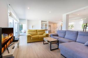 a living room with a blue couch and a tv at Boutique Ocean Terrace Luxury II - SSHOUSING in Igueldo