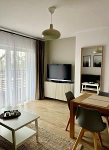 Televízia a/alebo spoločenská miestnosť v ubytovaní Apartamenty Lobeliowy Port