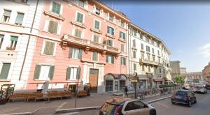 ein großes rosafarbenes Gebäude mit davor geparkt in der Unterkunft B&B Vatican Stories in Rom