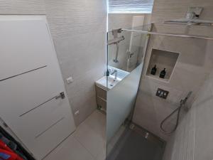 La petite salle de bains est pourvue d'une douche et d'un lavabo. dans l'établissement Apt 2 Chambres - Direct Gare Part-Dieu, Lyon - Ascenseur & Wi-Fi Gratuit, à Lyon