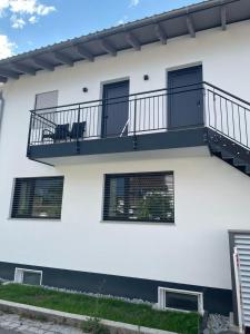 a white building with a balcony with two windows at Ferienzimmer Frank in Niederalteich