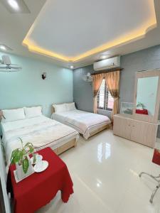 a bedroom with two beds and a red table at Sơn Tùng Hostel in Cat Ba