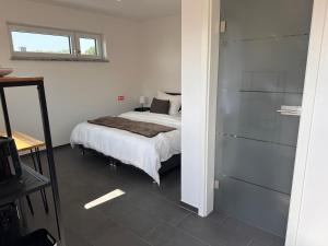 a white bedroom with a bed and a window at Ferienzimmer Frank in Niederalteich