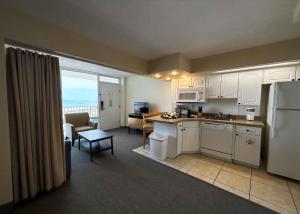 a kitchen with white cabinets and a view of the ocean at Outrigger Beach Club Resort in Ormond Beach