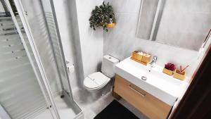 a bathroom with a toilet and a sink and a shower at Good Atmosphere Apartment in El Vendrell