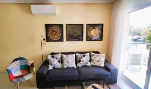 Good Atmosphere Apartment في إل فيندريل: غرفة معيشة مع أريكة وبعض الصور على الحائط