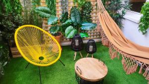 a patio with a hammock and a table and plants at Good Atmosphere Apartment in El Vendrell