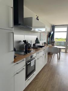 a kitchen with white appliances and a dining table at Appartement Belles Vacances in Quiberon