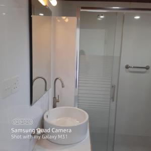 a bathroom with a sink and a shower with a mirror at Transit Studio Katunayake in Katunayake