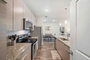 a kitchen with stainless steel appliances and wooden floors at Lavish 2BR Apartment in Tampa in Tampa